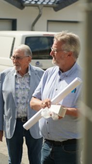 Mit prüfendem Blick und Bauplänen in der Hand begutachten Jürgen de Temple (l. / Stellvertretender Verbandsvorsteher des Zweckverbandes Sozialstation Adenau-Altenahr) und Uwe Szymanski (r. / Leiter der Sozialstation Adenau-Altenahr) die Fortschritte auf der Baustelle.